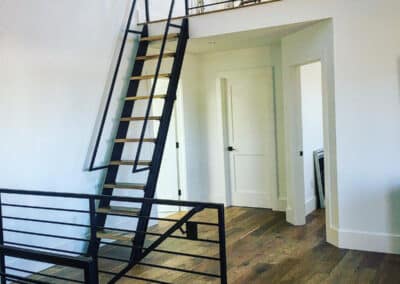 Tri-Level Living Areas Showcasing Black Steel Partition Walls and Black Steel Loft Ladder With Hand Railings