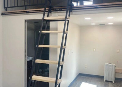 Loft Living Area With Black Steel Ladder and Black Partition Wall