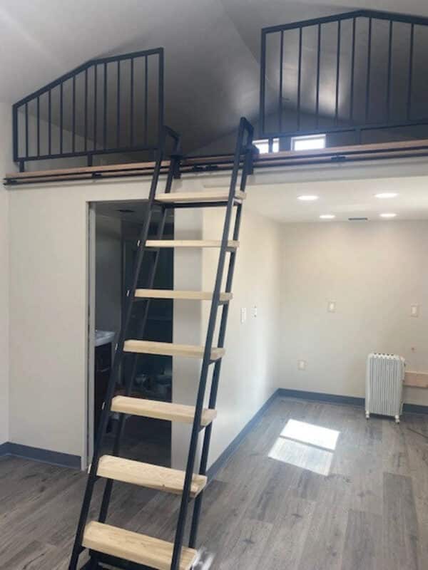 Loft Living Area With Black Steel Ladder and Black Partition Wall